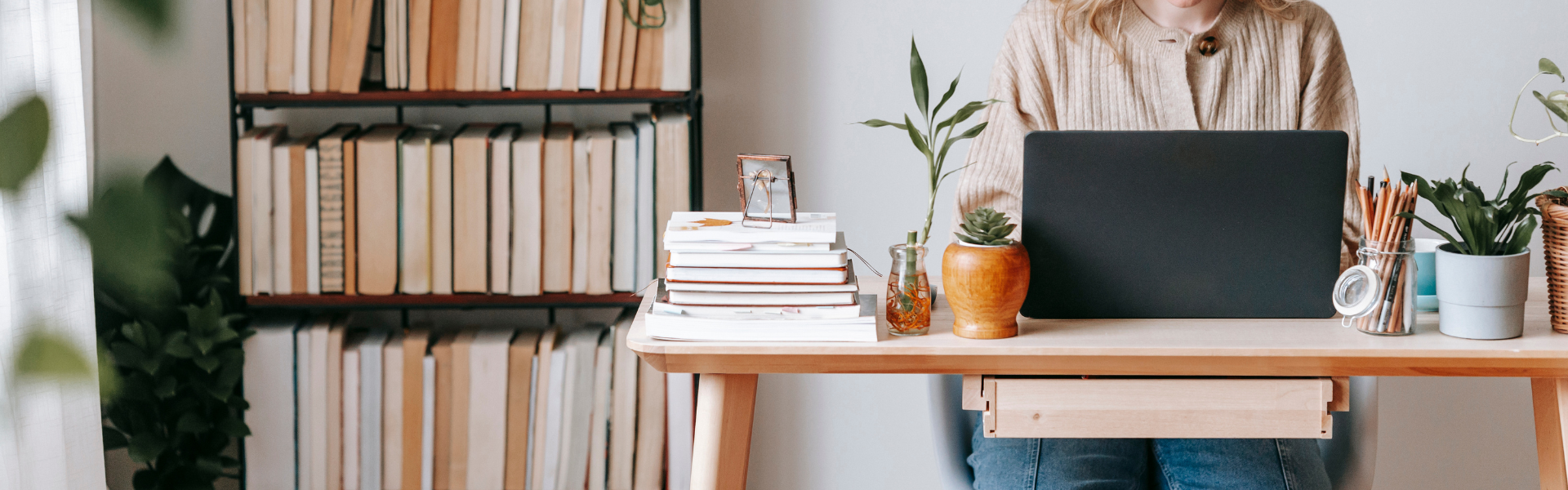 person at desk in front of bookcase