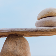 a single rock and two rocks balanced on a central rock point