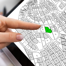 finger pointing at map on computer screen