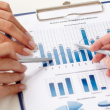 hands holding pens and pointing at business documents
