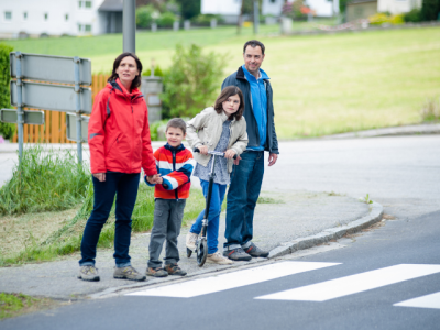 family standing on street corner at crosswalk