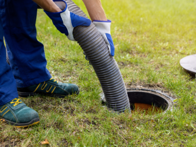 person pumping septic from a manhole access