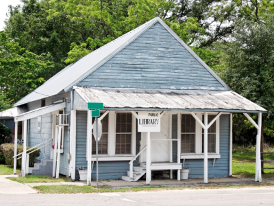 small blue building with "public library" sign