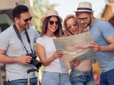 four smiling people looking at a map