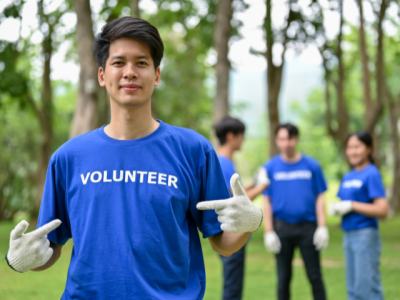 young person pointing at the word "volunteer" on their t-shirt