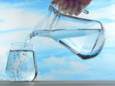 water being poured from a glass pitcher into a drinking glass