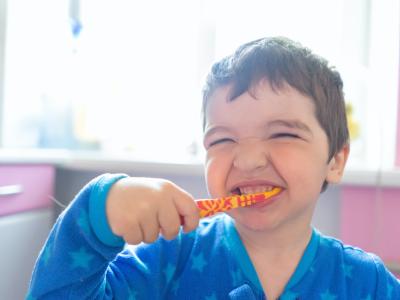 photo of smiling child brushing teeth