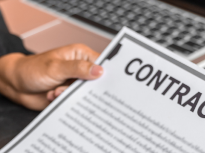 photo of hands offereing a contract to be signed