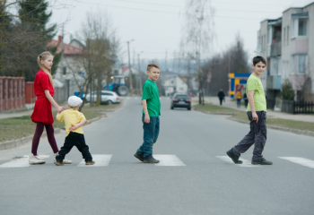 four children walking in a crosswalk