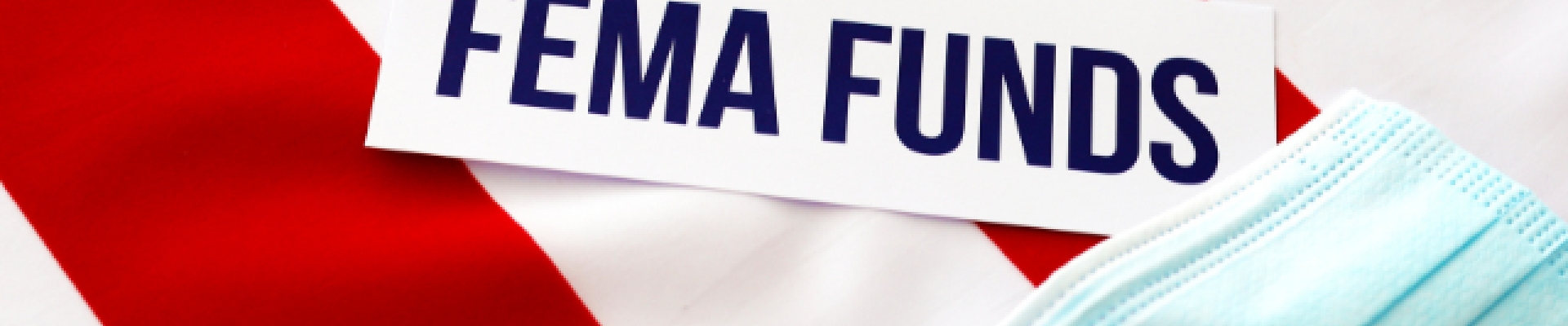 sign reading "FEMA Funds" with american flag in background