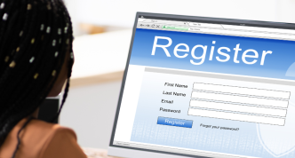 woman at computer with screen that reads "Register"