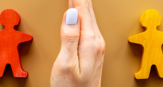 hand between to wooden people shaped blocks