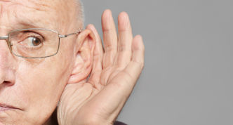 older man with glasses cupping hand behind his ear